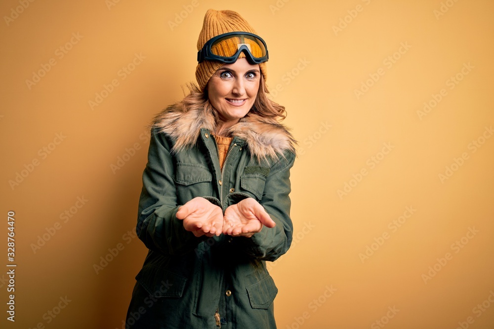 Middle age beautiful blonde skier woman wearing snow sportwear and ski goggles Smiling with hands palms together receiving or giving gesture. Hold and protection Middle age beautiful blonde skier woman wearing snow sportwear and ski goggles Smiling with hands palms together receiving or giving gesture. Hold and protection