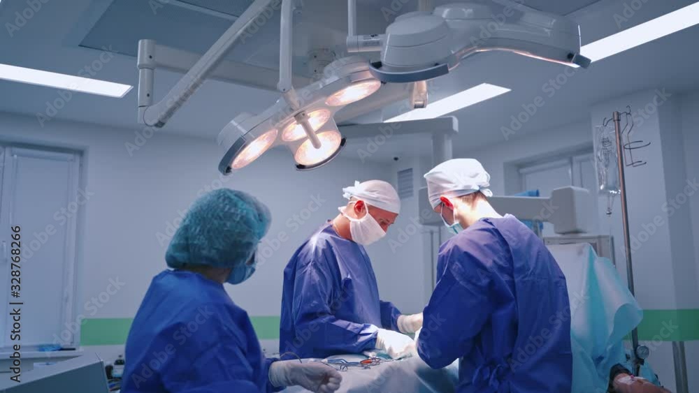 Surgeons Operating Process Surgery process. Group of surgeons doing an operation to a patient in ...