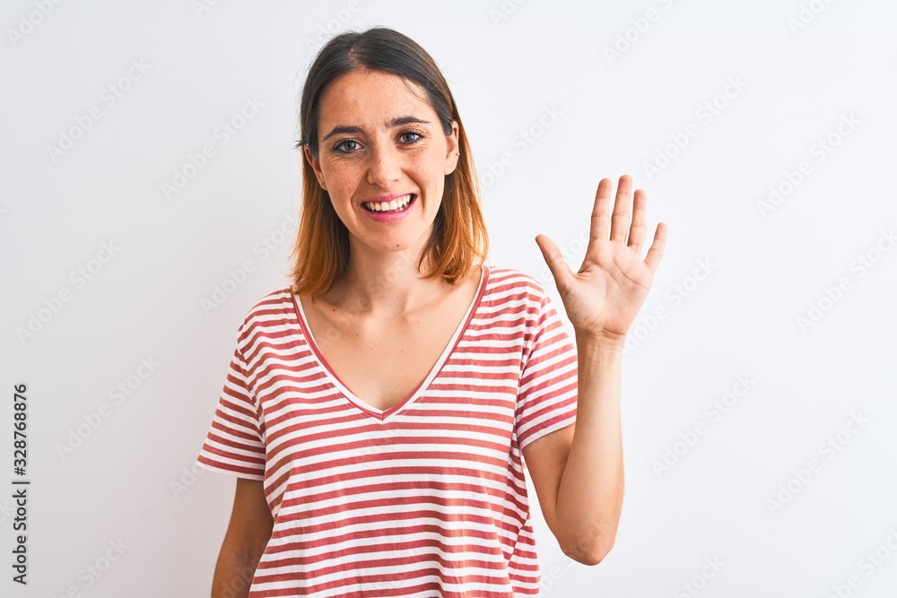 Beautiful redhead woman wearing casual striped red t-shirt over isolated background showing and pointing up with fingers number five while smiling confident and happy. Beautiful redhead woman wearing casual striped red t-shirt over isolated background showing and pointing up with fingers number five while smiling confident and happy.