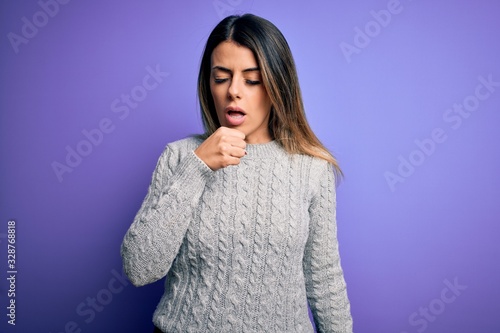 Young beautiful woman wearing casual sweater standing over isolated purple background feeling unwell and coughing as symptom for cold or bronchitis. Health care concept.