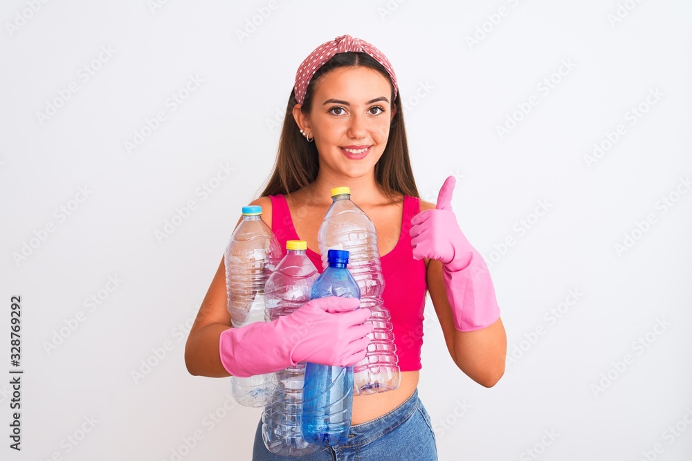Beautiful girl wearing cleaner gloves recycling plastic bottles over isolated white background happy with big smile doing ok sign, thumb up with fingers, excellent sign Beautiful girl wearing cleaner gloves recycling plastic bottles over isolated white background happy with big smile doing ok sign, thumb up with fingers, excellent sign
