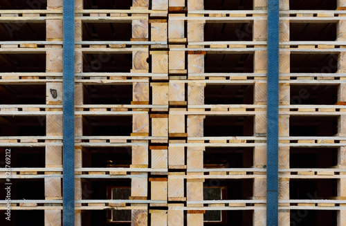 Close-up  texture and background of many wooden pallets stacked on top of one another and held together by tension belts