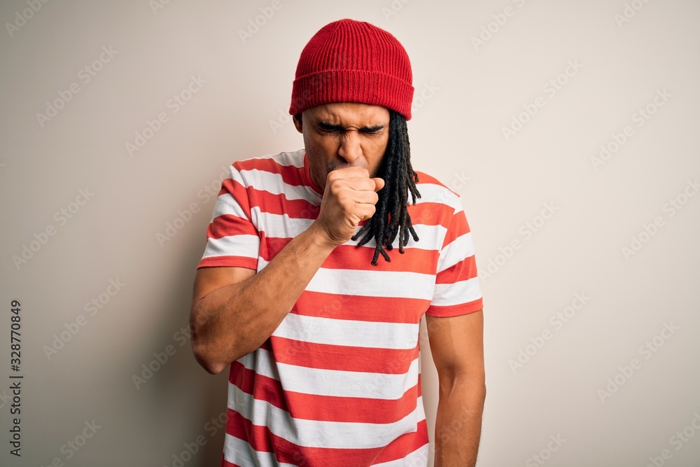 Fototapeta premium Young handsome african american man with dreadlocks wearing striped t-shirt and wool hat feeling unwell and coughing as symptom for cold or bronchitis. Health care concept.