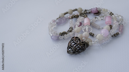 Beautiful female necklace with pink and purple stones and beads. Isolated on a white background. Stylish background.