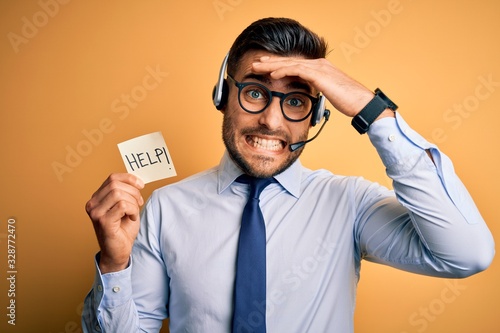 Obraz na plátne Business operator man with customer service headset from call center offering help and support stressed with hand on head, shocked with shame and surprise face, angry and frustrated