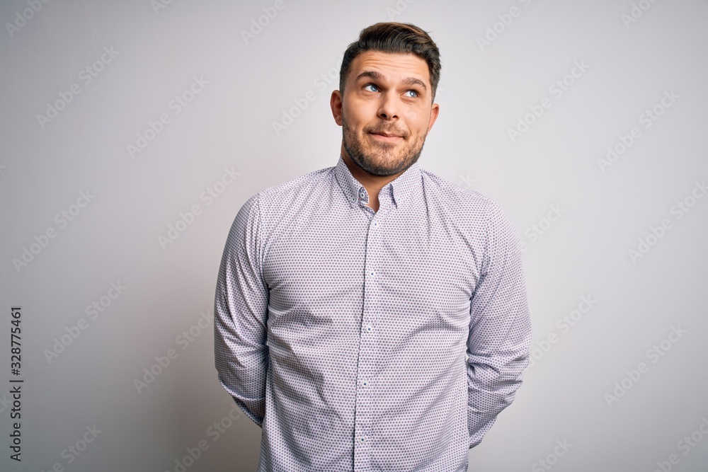 Young business man with blue eyes standing over isolated background smiling looking to the side and staring away thinking. Young business man with blue eyes standing over isolated background smiling looking to the side and staring away thinking.