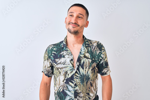 Young handsome man wearing Hawaiian summer shirt over isolated background smiling looking to the side and staring away thinking. photo