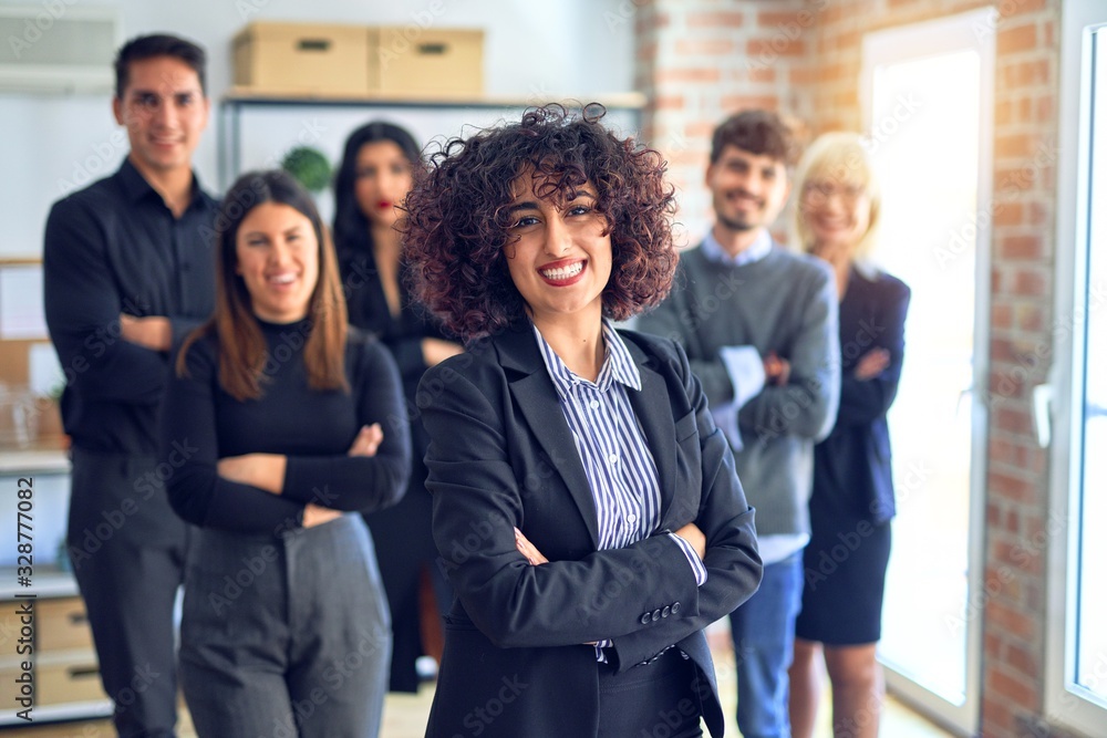 Obraz premium Group of business workers smiling happy and confident. Posing together with smile on face looking at the camera, young beautiful woman with crossed arms at the office
