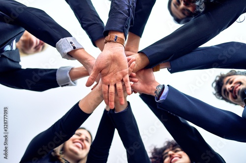 Group of business workers standing with hands together at the office