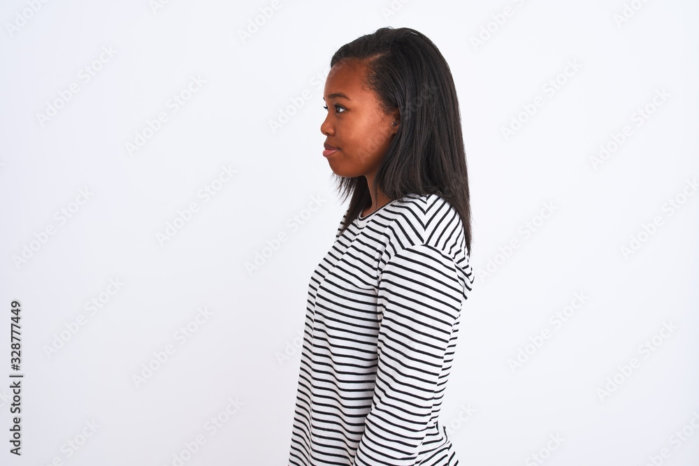 Beautiful young african american woman wearing winter sweater over isolated background looking to side, relax profile pose with natural face and confident smile.