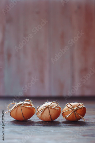 Easter beige eggs decorate with rope on brown wooden background