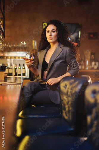 Elegant lady in a business suit, in a restaurant at a bar counter alone photo