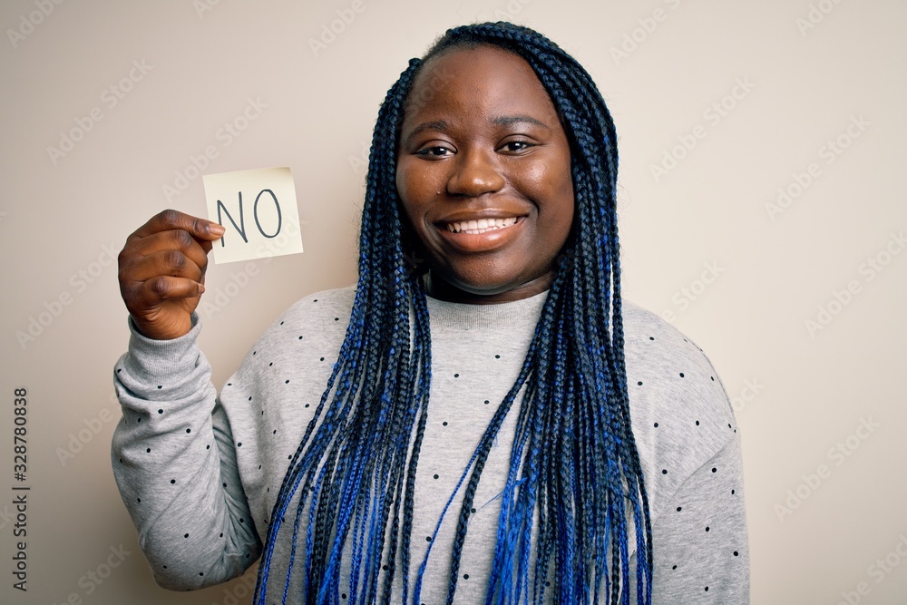 Young african american plus size woman with braids holding reminder paper with no message with a happy face standing and smiling with a confident smile showing teeth Young african american plus size woman with braids holding reminder paper with no message with a happy face standing and smiling with a confident smile showing teeth