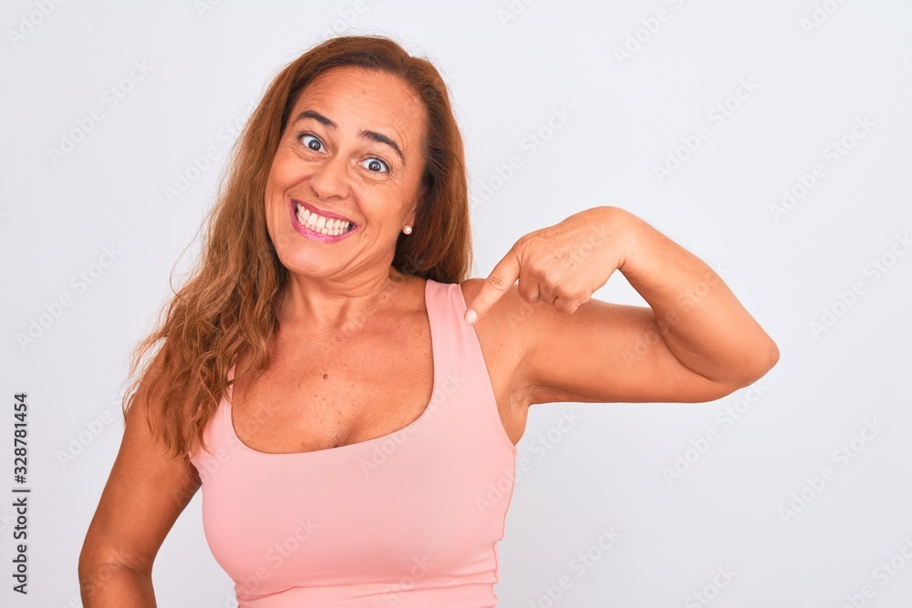 Fototapeta premium Middle age mature woman standing over white isolated background with surprise face pointing finger to himself
