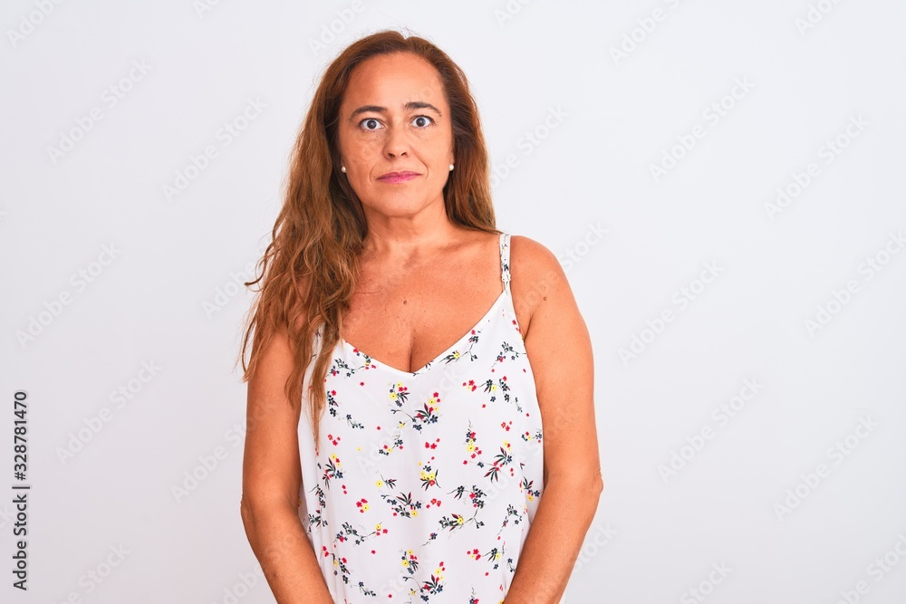 Middle age mature woman standing over white isolated background with serious expression on face. Simple and natural looking at the camera.