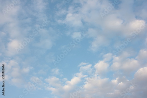 A pale blue sky with scenic white fluffy clouds in spring