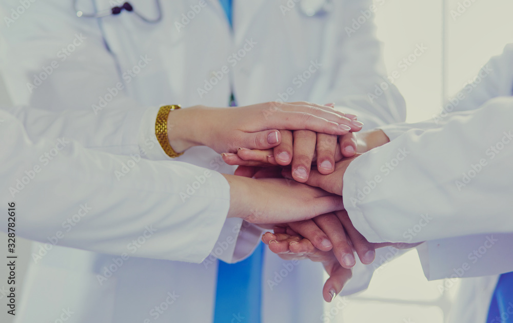 Doctors and nurses stacking hands. Isolated on white Doctors and nurses stacking hands. Isolated on white