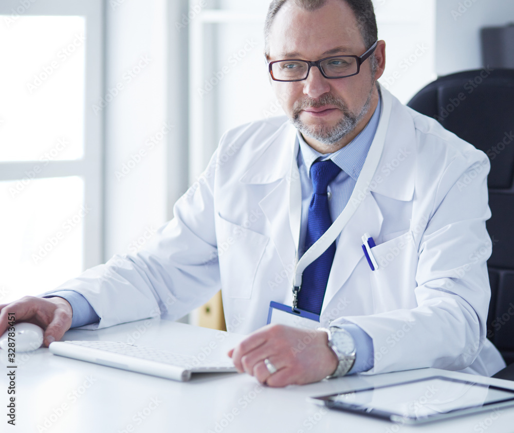 Portrait of senior doctor in office sitting at the desk Portrait of senior doctor in office sitting at the desk