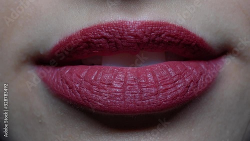 extreme close-up woman's lips blowing a kiss and smiling