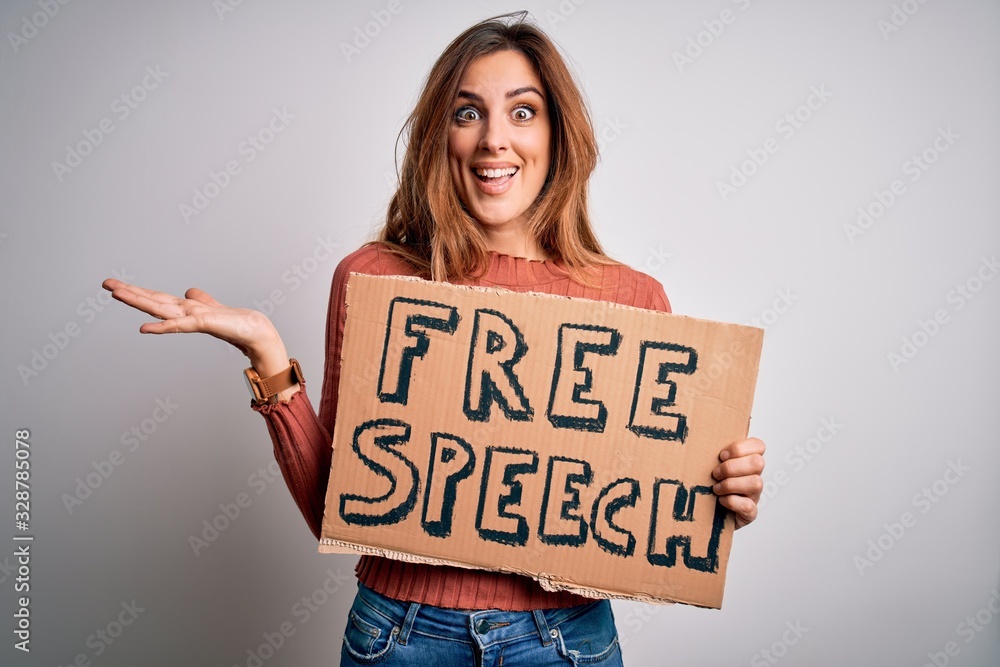 Young beautiful brunette woman asking for rights holding banner with free speech message very happy and excited, winner expression celebrating victory screaming with big smile and raised hands Young beautiful brunette woman asking for rights holding banner with free speech message very happy and excited, winner expression celebrating victory screaming with big smile and raised hands