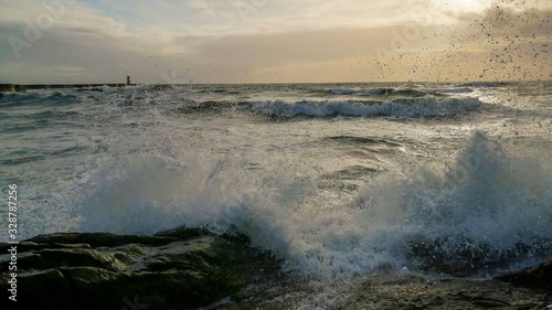 Colorful dramatic seascape with dark clouds and sun beams. Ocean surf.