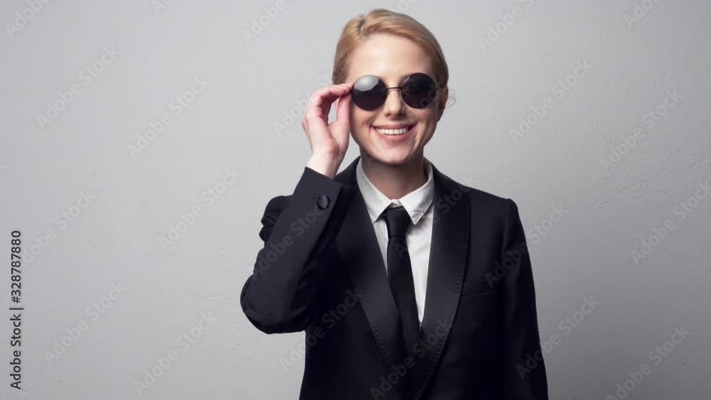smiling businesswoman in a classic business suit and sunglasses smiling businesswoman in a classic business suit and sunglasses
