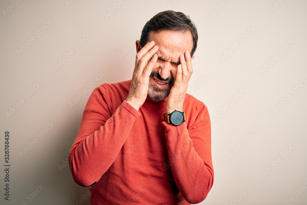 Middle age hoary man wearing casual orange sweater standing over isolated white background with hand on headache because stress. Suffering migraine. Middle age hoary man wearing casual orange sweater standing over isolated white background with hand on headache because stress. Suffering migraine.