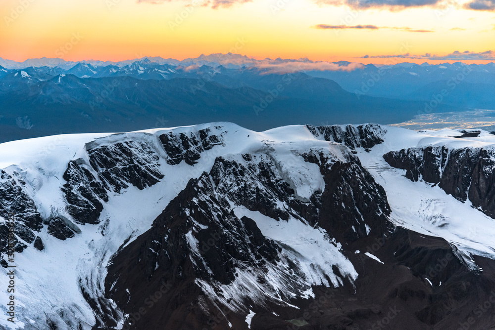 Obraz premium Winter Alaska Alpine Nature Scene with Snow Covered Mountain Peaks at Sunset Dusk with Beautiful Scenic Aerial Views 