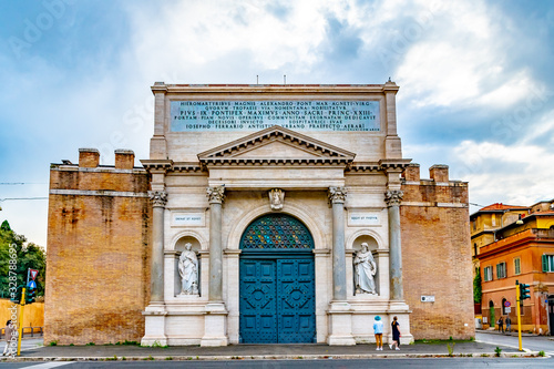 Fototapeta Naklejka Na Ścianę i Meble -  Rome, Italy. The outer face facade of the Porta Pia, a city gate in the Aurelian Walls of Rome, designed by Virginio Vespignani. People/ Tourists admiring and walking by this historic landmark.