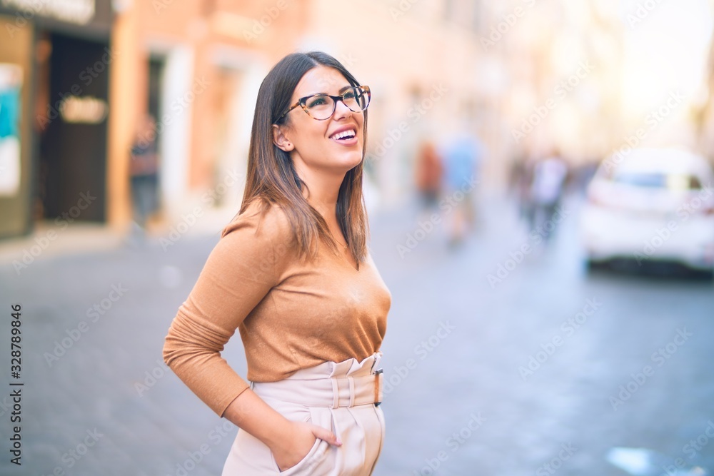 Young beautiful woman smiling happy and confident. Standing with smile on face at the town street