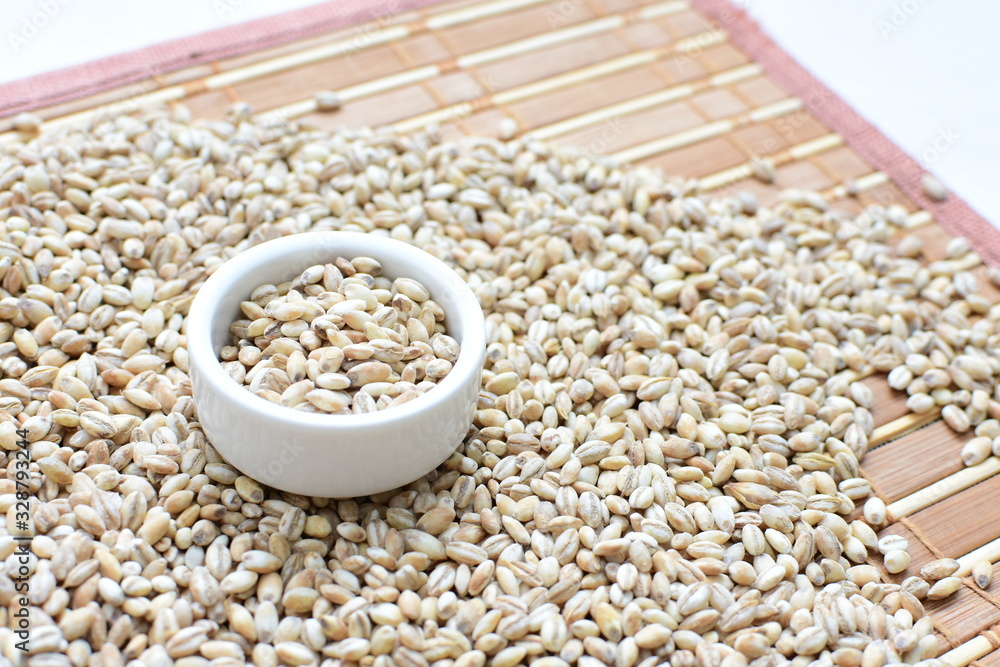 Raw barley grains, displayed in containers on textured background Raw barley grains, displayed in containers on textured background