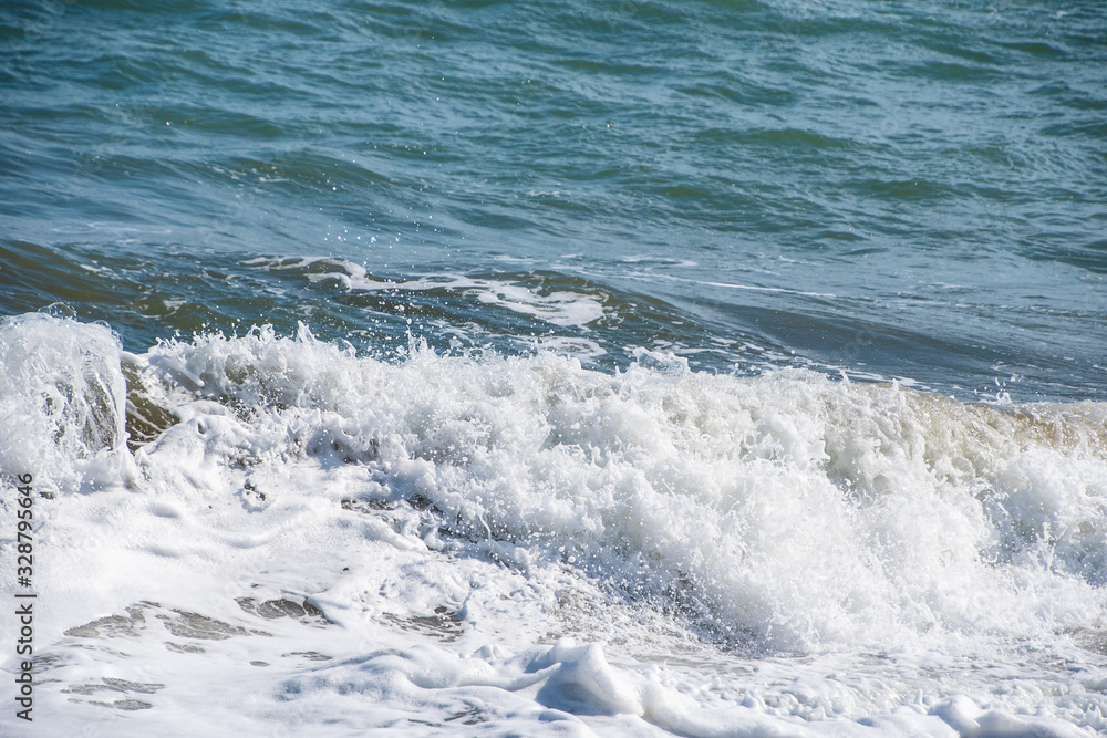 Mediterranean sea at sunset. Waves break on the sandy shore, sea foam. Natural background Mediterranean sea at sunset. Waves break on the sandy shore, sea foam. Natural background