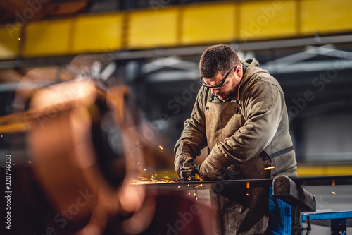 Worker Using Angle Grinder in Factory
