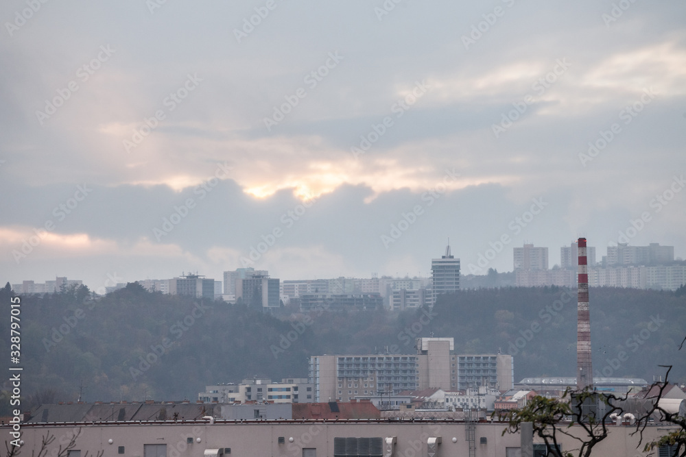 Panorama of Czech brutalist buildings, called Panelaky, in the suburbs of Brno, Czechia, with old industrial buildings with a factory chimney. They are symbols of communist architecture