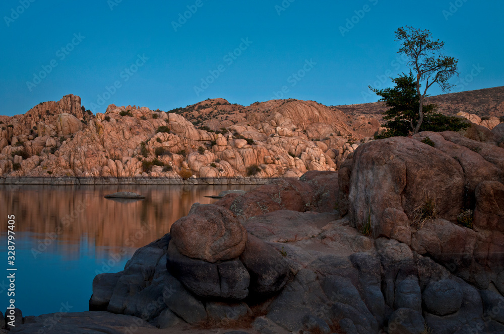 The granite rock formations of the Granite Dells area of Watson Lake glow in the twilight of a fading southwestern sunset.  Prescott, Arizona.