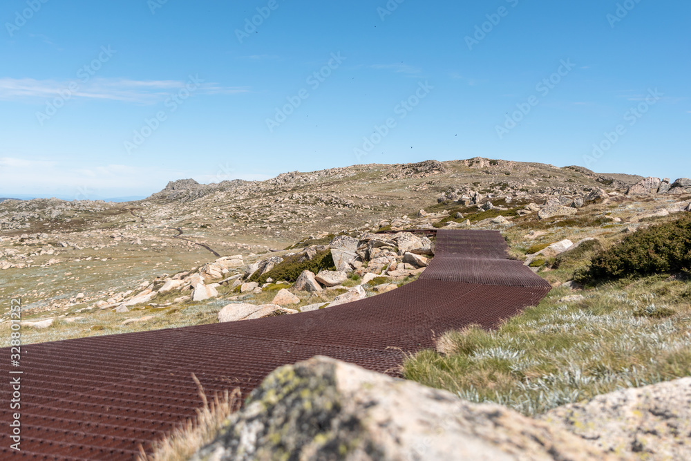 Beautiful scenic view of the rusty steel boardwalk connecting the summit of Mount Kosciuszko (2228m above sea level) with Thredbo chairlift in Kosciuszko National Park, New South Wales, Australia.