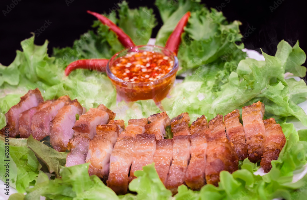 Thai roasted crispy pork on lettuce with Thai Spicy Sauce, Close up view Thai roasted crispy pork on lettuce with Thai Spicy Sauce, Close up view