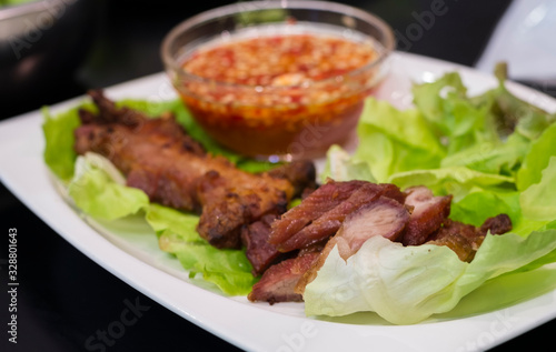 Thai roasted crispy pork on lettuce with Thai Spicy Sauce, Close up view