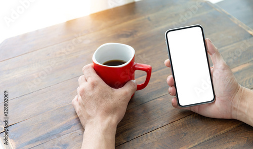 Mockup image blank white screen cell phone.man hand holding texting using mobile on desk at coffee shop.background empty space for advertise text.people contact marketing business,technology