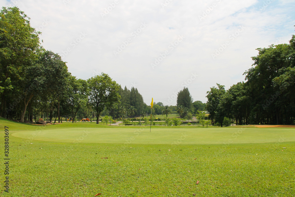 Fototapeta premium Wieczorne pole golfowe ma światło słoneczne padające na pole golfowe w Tajlandii