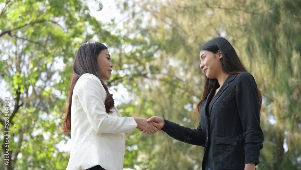 Two young business women join hands to congratulate the business cooperation : 4k Two young business women join hands to congratulate the business cooperation : 4k
