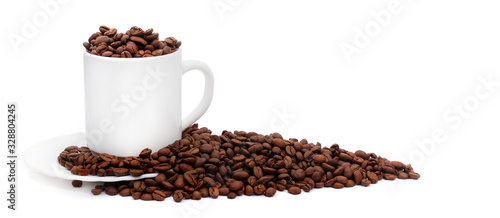 white coffee cup with saucer overfilled with roasted coffee beans isolated on white background with copy space, suitable for header or banner