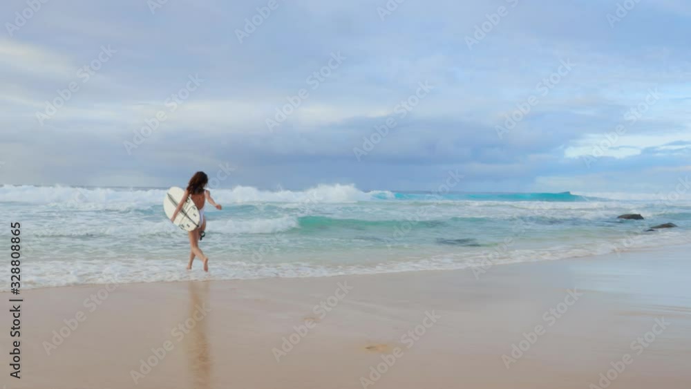 Surfer runs by Hawaiian beach, looking around for good waves, readiness for a surfing session Surfer runs by Hawaiian beach, looking around for good waves, readiness for a surfing session