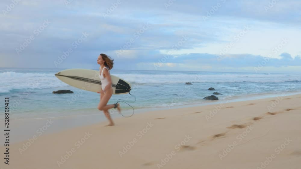 Surfer runs by Hawaiian beach, looking around for good waves, readiness for a surfing session Surfer runs by Hawaiian beach, looking around for good waves, readiness for a surfing session