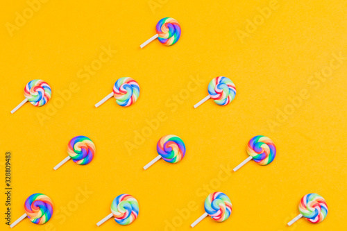 Lollipops are in a row. spiral candy pattern. lots of sweets on a yellow background. festive decoration