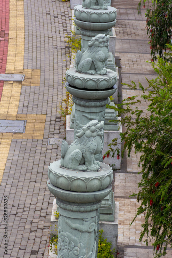 Line of chinese mythical beast statues next to a brick footpath