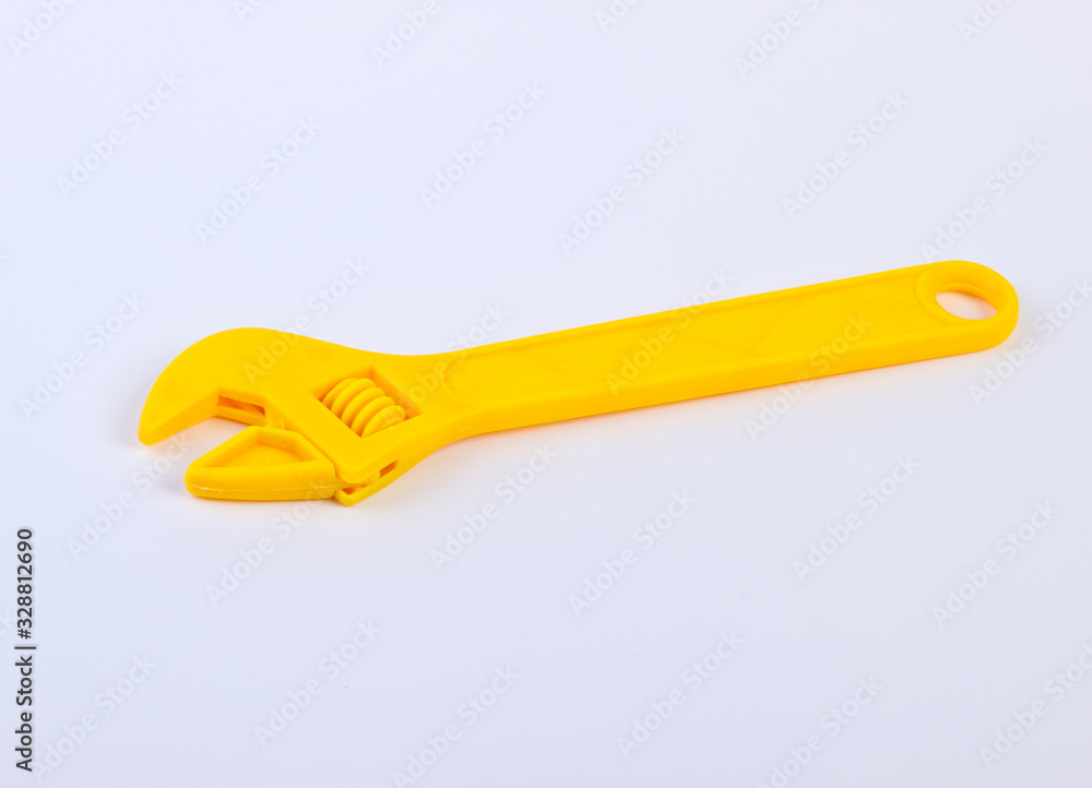 Yellow toy plastic wrench on white background close up Yellow toy plastic wrench on white background close up