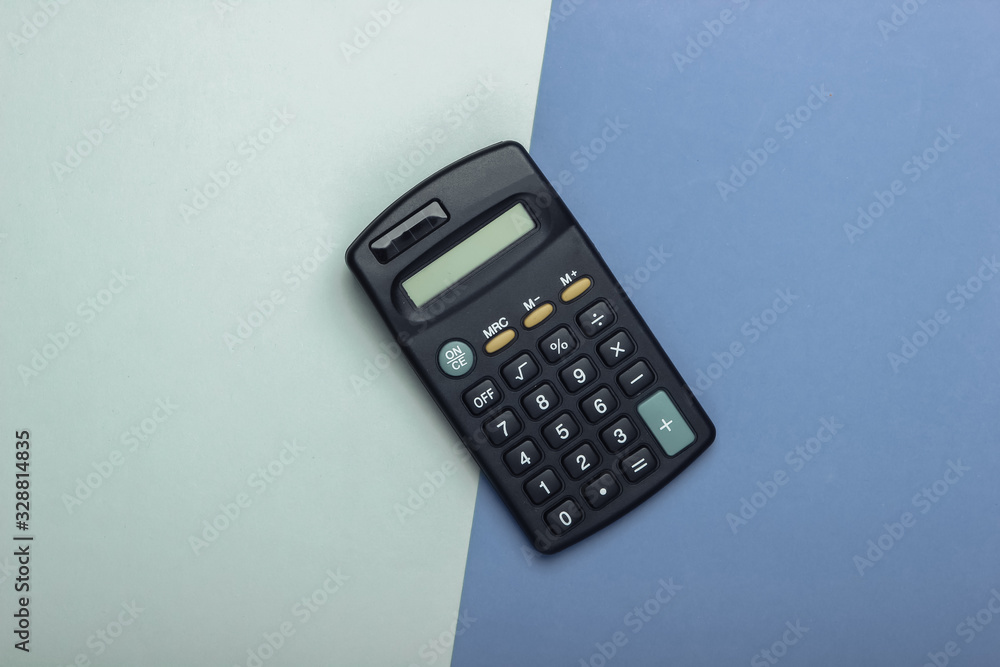 Black calculator on purple blue background. Top view Black calculator on purple blue background. Top view