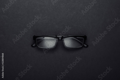 Classic eyeglasses on black background. Top view.