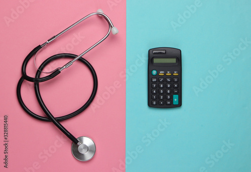 Stethoscope and calculator on a blue-pink pastel background. Top view